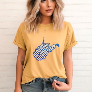 May include: A yellow t-shirt with a blue outline of the state of West Virginia. The words "mountain momma" are written inside the state outline.
