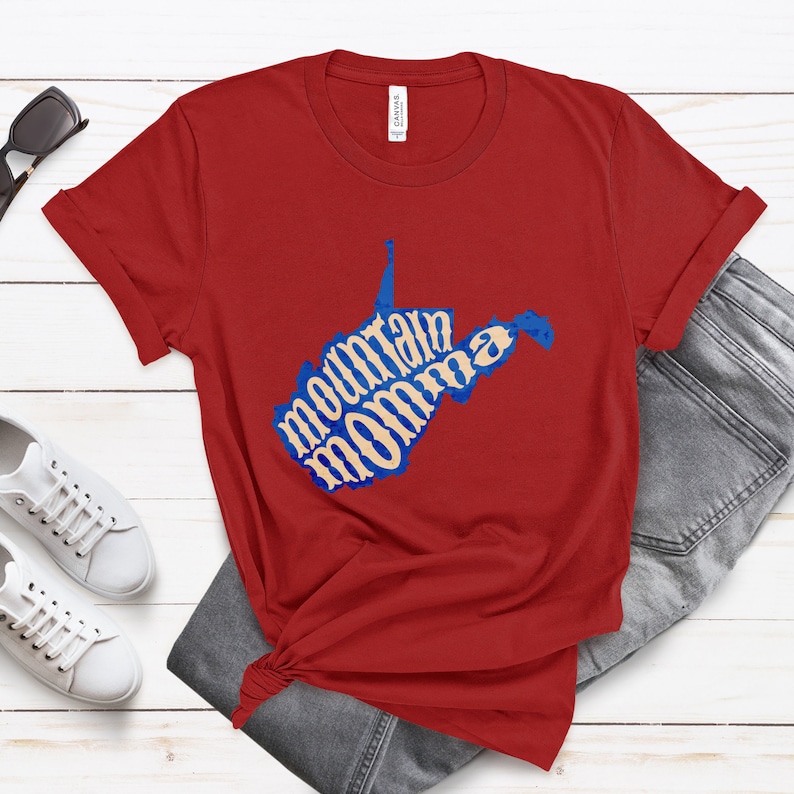May include: Red t-shirt with a blue outline of the state of West Virginia. The words "mountain momma" are written inside the state outline in a cream color.