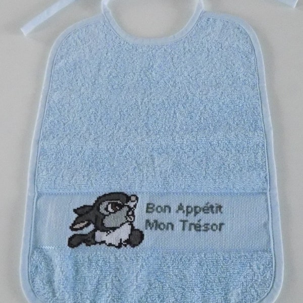 Sky blue terrycloth bib, hand-embroidered in cross stitch, Thumper motif, "Bon Appétit Mon Trésor" inscription.