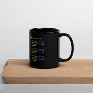 Könnte beinhalten: Schwarze Kaffeetasse mit weißem und blauem Code-Text. Die Tasse hat einen großen Henkel und steht auf einer Holzoberfläche. Der Text enthält die Wörter "working" und "hour".