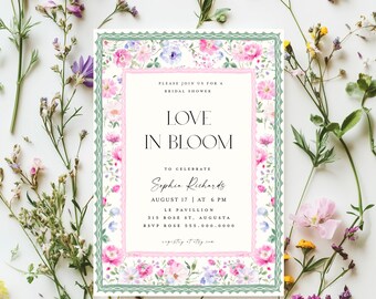 May include: A floral bridal shower invitation with a pink and green border. The text reads "Love in Bloom" to celebrate "Sophia Richards" on August 17th at 6 PM at Le Pavillion, 315 Rose St, Augusta. RSVP 555.000.0000.