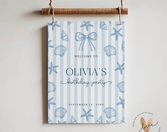 May include: A blue and white striped party sign with seashell and starfish illustrations. The sign reads "WELCOME TO OLIVIA'S birthday party" and "SEPTEMBER 10, 20XX". The sign is suspended by a wooden rod and twine.