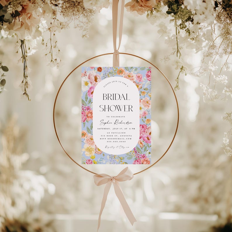 Pu&ograve; includere: Un invito a un bridal shower floreale con uno sfondo blu chiaro e fiori rosa, bianchi e gialli. Il testo recita "Si prega di unirsi a noi per un Bridal Shower per celebrare Sophia Richardson Sabato 17 luglio, alle 18:00 Le Pavillion 515 Rose St, Augusta RSVP: sophiar@email.com Lista nozze: &Egrave; facile"