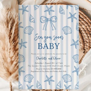 May include: Baby shower invitation with a nautical theme. The invitation features a blue and white striped background with illustrations of seashells and starfish. The text "Sea you soon BABY" is displayed in a script font.