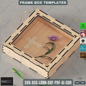 May include: A wooden frame box template with the text "FRAME BOX TEMPLATES". Inside the box are Scrabble tiles spelling "MAMA" and a purple flower. The frame is made of light-colored wood with black accents. The image also includes the text "SVG-XCS-LBRN-DXF-PDF-AI-CDR".