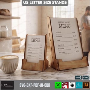 May include: Two light-colored wooden menu stands with angled backs and front ledges, displaying white menu cards titled Artisan Bakery Menu. The stands are designed for US letter size paper and feature visible 1/8 inch material thickness.