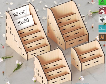 Puede incluir: Una plantilla de soporte de exhibición para tarjetas cortada con láser. El soporte tiene cuatro estantes y está hecho de madera. La plantilla está disponible en los formatos SVG, XCS, LBRN, DXF, PDF, AI y CDR.