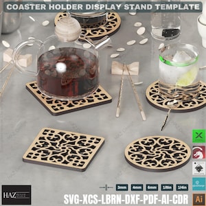 May include: A set of five laser cut wooden coasters with intricate designs. The coasters are in a square and round shape. The coasters are displayed on a table with a teapot and glasses.