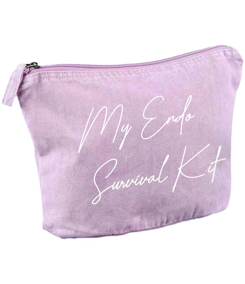 May include: A light purple canvas cosmetic bag with a zipper closure. The bag has the words "My Endo Survival Kit" printed in white script across the front. The bag is designed to hold personal care items.