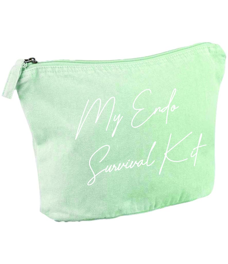 May include: A light green canvas cosmetic bag with a zipper closure. The bag features the text "My Endo Survival Kit" in a white script font. The bag is designed to hold personal care items.