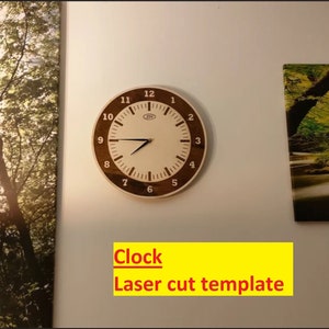 Può includere: Un modello di orologio da taglio laser con una cornice in legno marrone e un quadrante bianco. Il quadrante dell'orologio ha lancette nere e numeri neri. Il testo "Clock Laser cut template" è scritto sotto l'orologio.