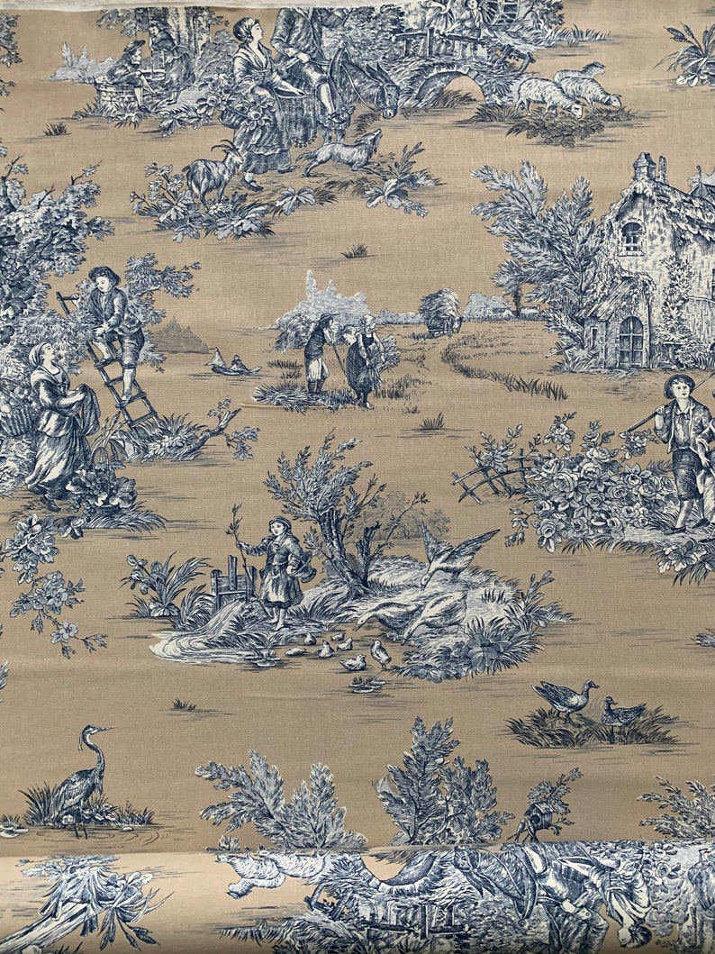 May include: A beige fabric with a blue and white toile pattern featuring a pastoral scene with people, animals, and houses. The pattern is repeated throughout the fabric.