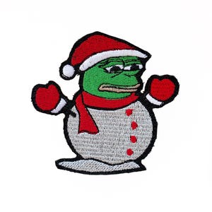 May include: A green frog wearing a red Santa hat and scarf, with red mittens, is made into a snowman. The snowman has a white body with red buttons and a black outline.