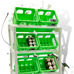 Puede incluir: Una estantería de metal blanco con seis cajas de plástico verde. Las cajas tienen un patrón de rejilla y están apiladas en dos filas de tres. Algunas de las cajas contienen baterías.