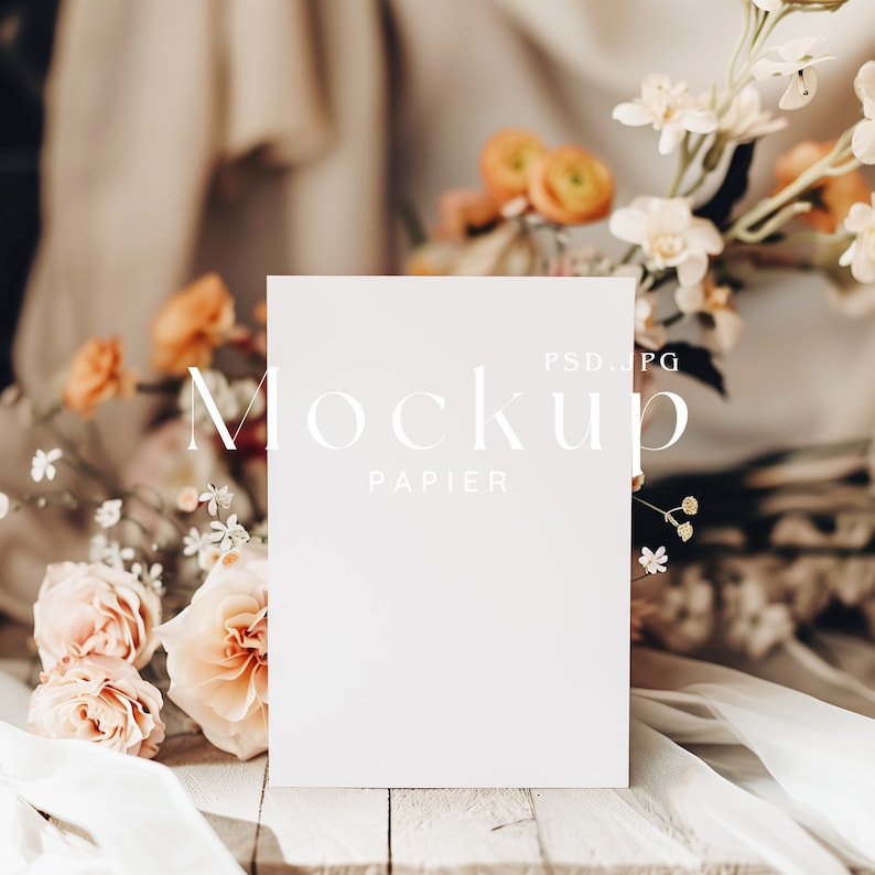 Puede incluir: Una maqueta de tarjeta blanca con el texto "Mockup Papier PSD.JPG" sobre una superficie de madera blanca con un ramo de flores rosas y blancas.
