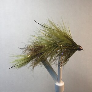 May include: A green and brown fly fishing lure with a bead head.
