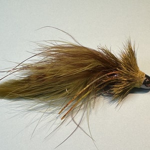 May include: A brown and green fly fishing lure with a long tail of feathers.