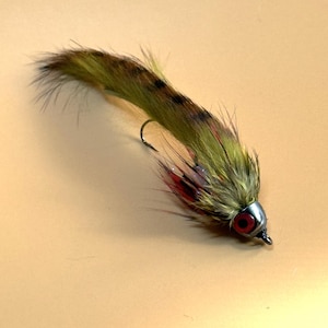 May include: A green and brown fly fishing lure with red and white accents and a silver hook.