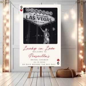 Puede incluir: Una tarjeta blanca con un coraz&oacute;n rojo y el n&uacute;mero 9 en la esquina superior izquierda. La tarjeta tiene una foto en blanco y negro de una mujer de pie frente al letrero "Welcome to Fabulous Las Vegas". El texto "Lucky in Love" est&aacute; escrito en cursiva roja. El texto "Welcome to Prescilla's Bridal Shower 04.10.20XX 68 Days Before the Big Day!" est&aacute; escrito en negro. Un coraz&oacute;n rojo con el n&uacute;mero 6 est&aacute; en la esquina inferior derecha.