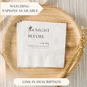 May include: White paper napkin with black text that reads "the NIGHT BEFORE celebrating HAILEY & ANTHONY WE'RE SO GLAD YOU'RE HERE".