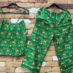 May include: Green paisley print pajama set with a tank top and wide-leg pants.