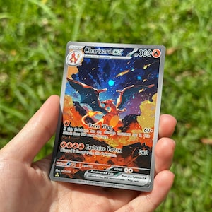 Op de afbeelding: Een Charizard EX Pokémon-verzamelkaart. De kaart toont een levendige illustratie van een Charizard met oranje en rode vlammen, tegen een blauwe en oranje achtergrond. De kaart bevat tekst, waaronder "Brave Wing" en "Explosive Vortex".