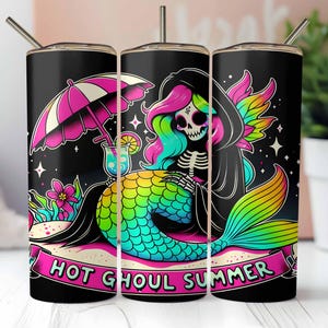 Op de afbeelding: Drie roestvrijstalen bekers met een zwarte achtergrond en een kleurrijke illustratie van een skelet-zeemeermin met een roze-witte parasol, een cocktail en de tekst "Hot Ghoul Summer".