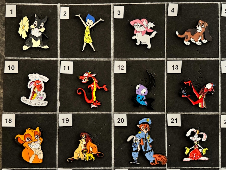 May include: A collection of cartoon character charms, including a rabbit with a flower, a girl with arms raised, a white cat with a pink bow, and a brown dog. Other charms feature a dragon, a lion, and a fox in a police uniform.
