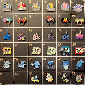 May include: A collection of Disney character pins, including Mickey Mouse, Ariel, Simba, and others. The pins feature various designs, such as character heads, castles, and themed logos. The pins are displayed on a black background.