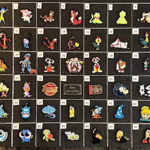 May include: A collection of colorful character charms, including cartoon figures like Simba, Baymax, and Genie. The charms are arranged on a black surface, showcasing a variety of designs and colors. These charms are likely for shoes or bracelets.