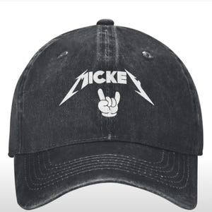 May include: Black distressed baseball cap with a white graphic of a cartoon hand making a rock and roll sign and the text "MICKEY" above it.