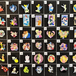 May include: A collection of colorful enamel pins featuring various cartoon characters. The pins showcase characters from popular animated movies and TV shows, with vibrant colors and detailed designs. The pins are arranged on a black surface.