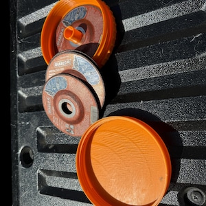 Puede incluir: Tres contenedores de almacenamiento de plástico naranja con un juego de tres discos de corte de metal redondos. Los discos están etiquetados con "Diablo Metal Cut-Off Wheels".