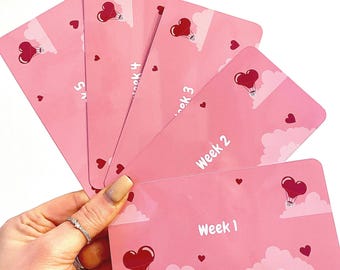 Puede incluir: Cinco tarjetas rosas con un diseño de globo aerostático en forma de corazón. Cada tarjeta tiene un número de semana diferente, de la semana 1 a la semana 5.