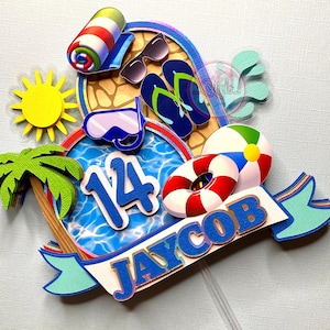 May include: A blue and white cake topper with a pool, palm tree, beach ball, flip flops, and goggles. The cake topper also includes the name "JAYCOB" and the number "14".