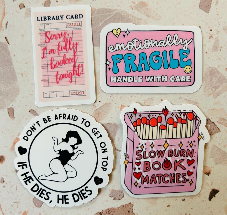 May include: Four stickers with various designs. One is a pink library card with the text "Sorry, I'm fully booked tonight!". Another is a pink sticker with "emotionally FRAGILE HANDLE WITH CARE". A third sticker says "DON'T BE AFRAID TO GET ON TOP IF HE DIES, HE DIES". The last sticker is a pink matchbox with "SLOW BURN BOOK MATCHES".