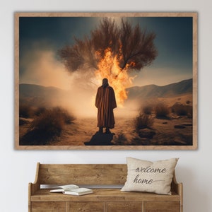 May include: A person in a long brown robe stands in a desert landscape. A tree behind them is engulfed in flames. The sky is a hazy orange and yellow.
