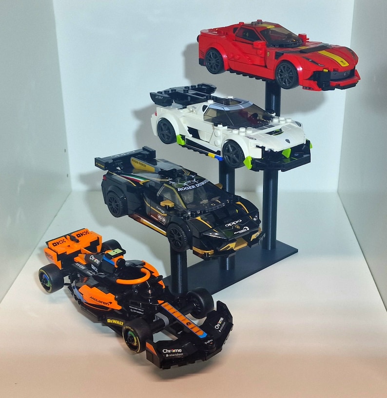 K&ouml;nnte beinhalten: Ein schwarzer, wei&szlig;er und roter Lego-Auto-Pr&auml;sentationsst&auml;nder mit drei verschiedenen Lego-Autos. Das oberste Auto ist rot mit einem gelben Streifen, das mittlere Auto ist wei&szlig; mit gr&uuml;nen Akzenten und das unterste Auto ist schwarz mit goldenen Akzenten. Das unterste Auto ist ein Formel-1-Rennwagen mit dem Schriftzug "Chrome" an der Seite.
