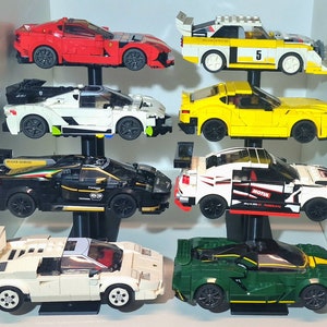 K&ouml;nnte beinhalten: Eine Sammlung von zehn Miniatur-Spielzeugautos, die auf einem mehrstufigen St&auml;nder ausgestellt sind. Die Autos sind in verschiedenen Farben, darunter Rot, Wei&szlig;, Gelb, Schwarz und Gr&uuml;n. Die Autos sind alle unterschiedlicher Marke und Modell, darunter ein roter Sportwagen, eine wei&szlig;e Limousine, ein gelber Cabrio, ein schwarzer Rennwagen und ein gr&uuml;ner LKW.