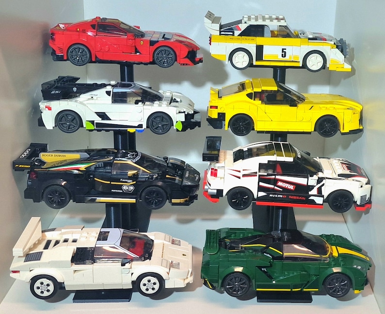 K&ouml;nnte beinhalten: Eine Sammlung von zehn Miniatur-Spielzeugautos, die auf einem mehrstufigen St&auml;nder ausgestellt sind. Die Autos sind in verschiedenen Farben, darunter Rot, Wei&szlig;, Gelb, Schwarz und Gr&uuml;n. Die Autos sind alle unterschiedlicher Marke und Modell, darunter ein roter Sportwagen, eine wei&szlig;e Limousine, ein gelber Cabrio, ein schwarzer Rennwagen und ein gr&uuml;ner LKW.