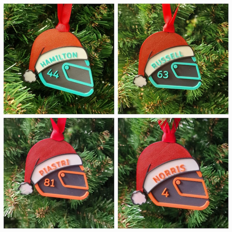 Op de afbeelding: Vier kerstversieringen in de vorm van racehelmen, elk met een kerstmuts. De ornamenten zijn zwart, teal en oranje, met de namen "HAMILTON", "RUSSELL", "PIASTRI" en "NORRIS" en de nummers 44, 63, 81 en 4.