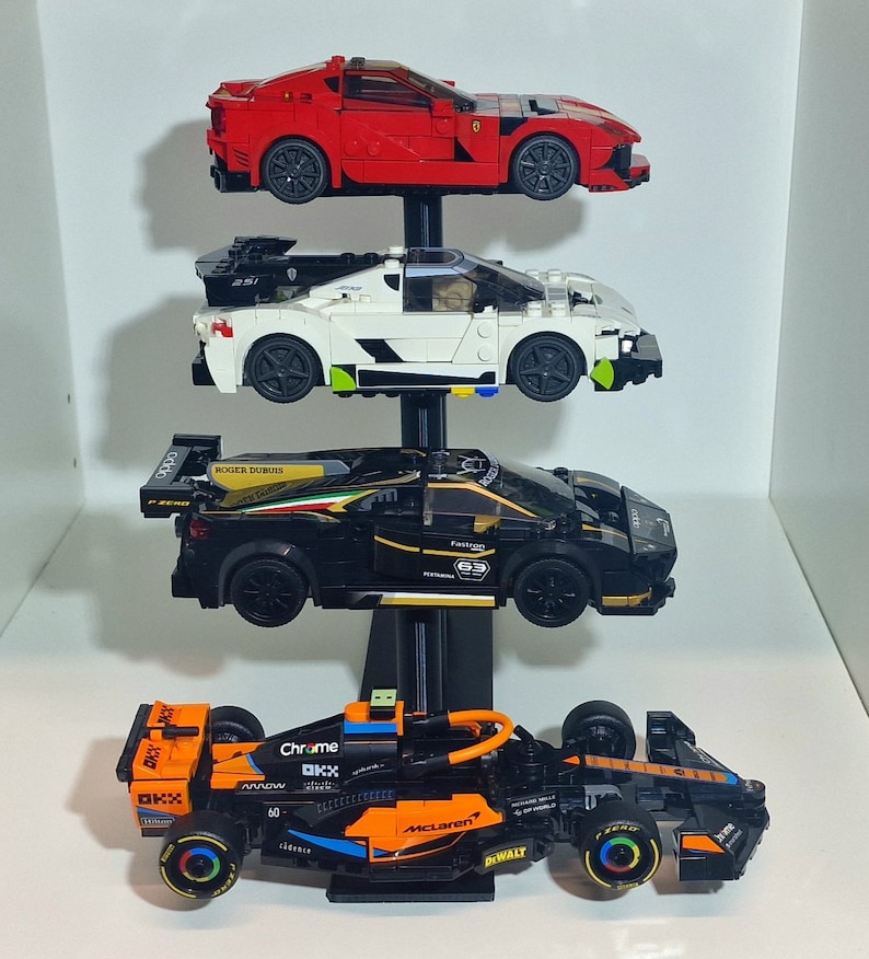 K&ouml;nnte beinhalten: Ein schwarzer St&auml;nder mit vier Ebenen zeigt vier verschiedene Lego-Automodelle. Die oberste Ebene zeigt einen roten Ferrari, die zweite Ebene zeigt einen wei&szlig;en und schwarzen McLaren, die dritte Ebene zeigt einen schwarzen Lamborghini und die unterste Ebene zeigt einen orangefarbenen McLaren Formel-1-Wagen.