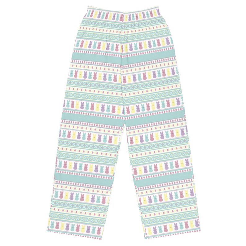 May include: Light blue pajama trousers with a repeating pattern of colourful Easter bunny figures. The trousers feature horizontal stripes with the bunnies in yellow, purple, and pink. The background is a light blue colour.