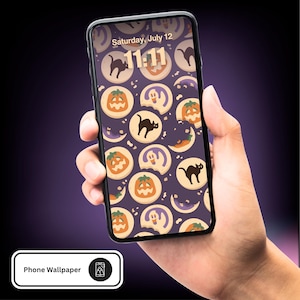 May include: A smartphone displaying a Halloween-themed wallpaper. The wallpaper features repeating illustrations of jack-o'-lanterns, black cats, ghosts, and crescent moons on a purple background. The time displayed is 11:11 on Saturday, July 12.