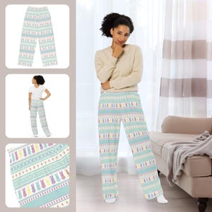 May include: Light blue pyjama trousers featuring a repeating pattern of pastel-coloured Easter bunnies. The trousers have a wide-leg design and a comfortable fit. The theme is Easter and spring.