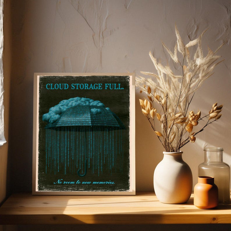 Framed poster on a console table with pampas grass on the left. The cyan headline and cloud above an umbrella formed of binary digits are visible in the top half of the print.