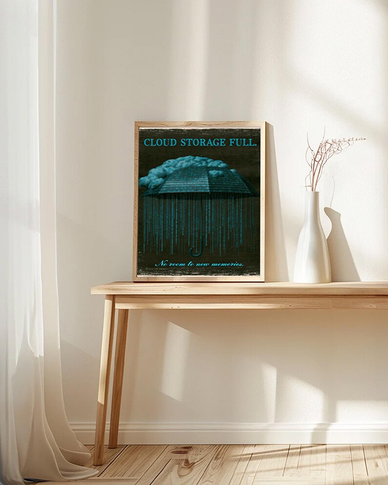 Small framed poster on a slim table with white ceramic vases. The image shows the cyan-coded umbrella and cloud on a dark textured background with distressed light paper border.