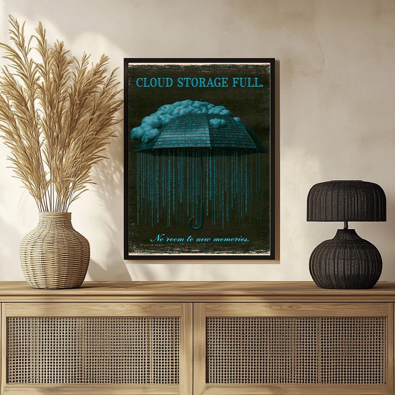 Leaning poster in a warm-toned room with dried floral stems at left. The cyan cloud and umbrella of binary digits dominate the composition while thin script text appears near the lower edge.