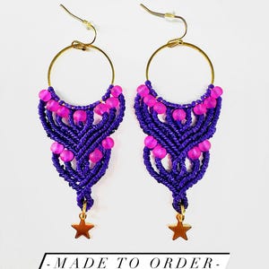 May include: A pair of earrings featuring gold-tone hoops with purple macrame cord knots, translucent hot pink beads, and a small gold-tone star charm at the bottom. The text "Starstruck" "Fully customizable" and "- MADE TO ORDER -" is visible.