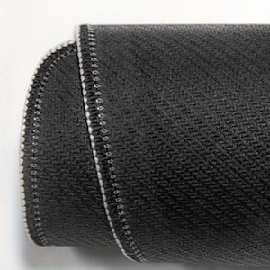 May include: Close-up of a black mouse pad with a textured surface and white stitching around the edges.